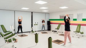 Three women engage in a workout session in a brightly lit, modern fitness studio in Yalova, Türkiye.